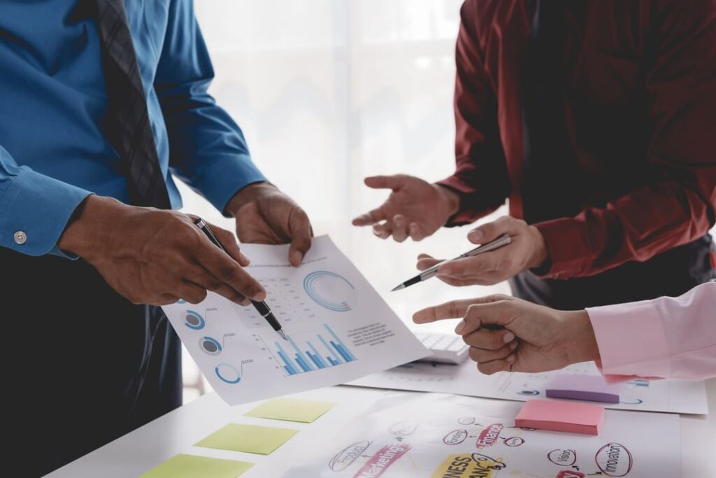 Profissionais analisando gráficos e discutindo dados para avaliar a maturidade analítica de uma organização.
